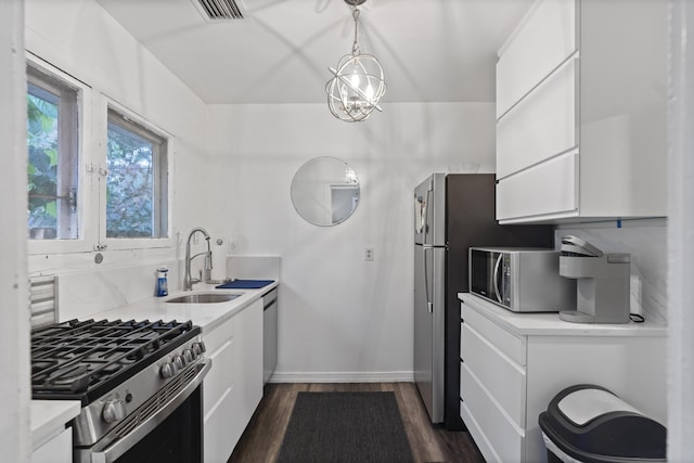 kitchen featuring dark wood-type flooring, a sink, white cabinetry, appliances with stainless steel finishes, and light countertops