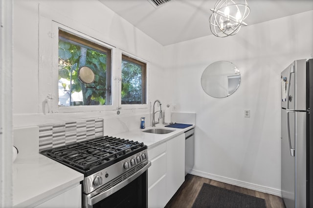 kitchen with a sink, decorative backsplash, light countertops, stainless steel appliances, and white cabinetry