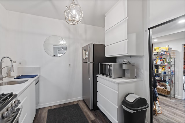 kitchen featuring dark wood-type flooring, a sink, white cabinetry, stainless steel appliances, and light countertops