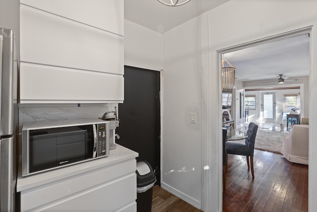 kitchen with light countertops, dark wood finished floors, a ceiling fan, and white cabinetry