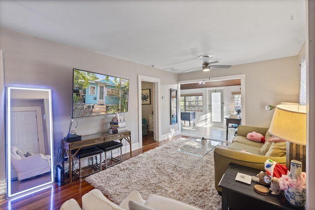 living room with a ceiling fan, wood finished floors, and baseboards