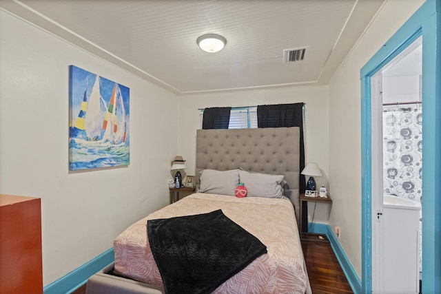 bedroom featuring visible vents, baseboards, and wood finished floors