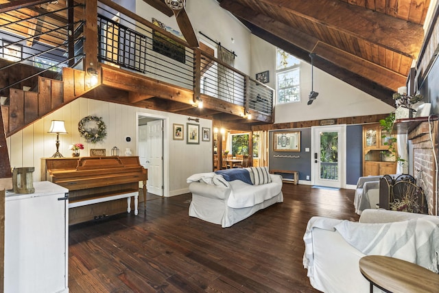 living room featuring a fireplace, a high ceiling, baseboards, and wood-type flooring