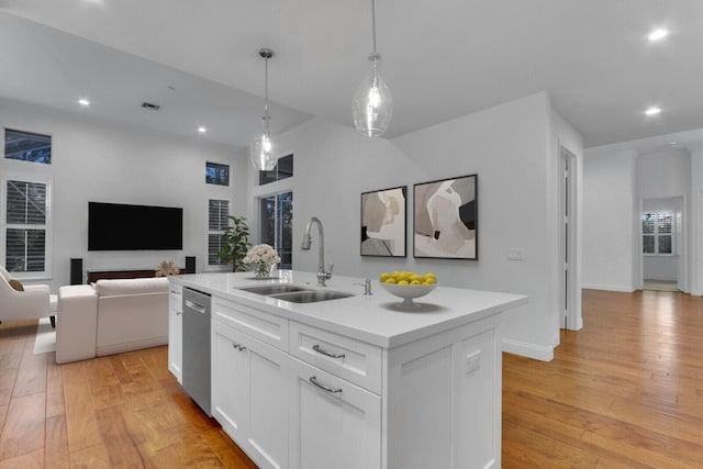 138 Victorian Ln, Jupiter, FL 33458 - kitchen with stainless steel dishwasher, an island with sink, a sink, and light wood-type flooring