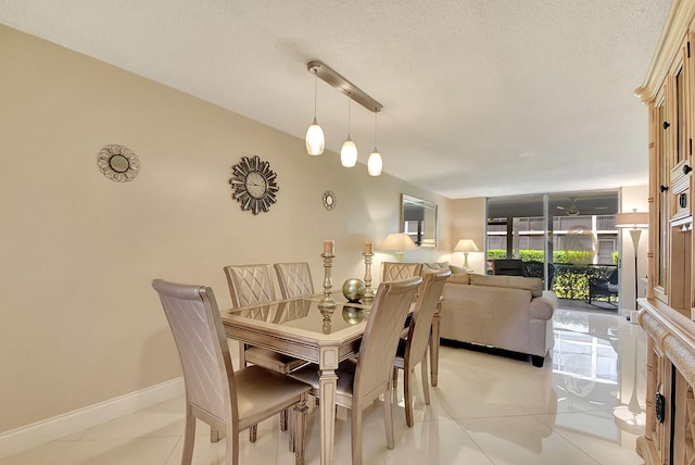 dining room with light tile patterned floors, baseboards, and a textured ceiling