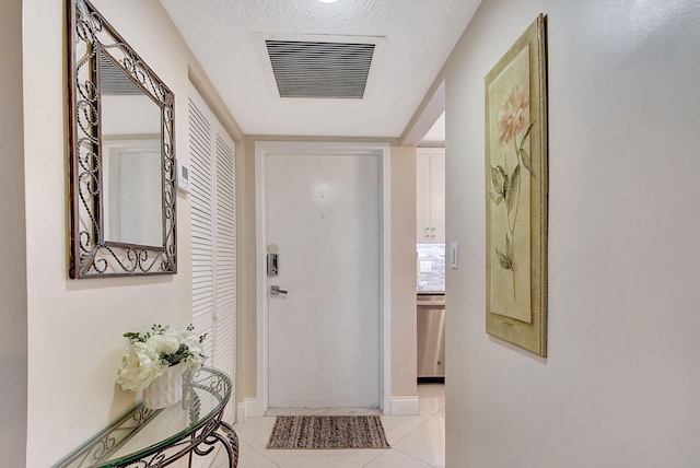 doorway featuring light tile patterned floors, baseboards, and visible vents