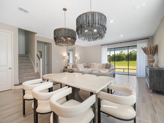 dining area featuring visible vents, recessed lighting, stairway, an inviting chandelier, and light wood finished floors