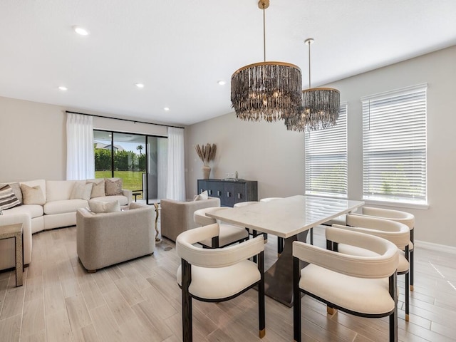 dining space with recessed lighting, baseboards, light wood-style floors, and a chandelier