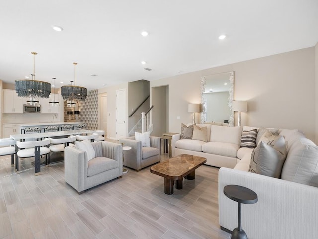 living room featuring stairs, recessed lighting, and light wood-type flooring