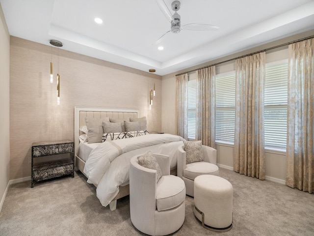 bedroom featuring recessed lighting, a tray ceiling, baseboards, and carpet