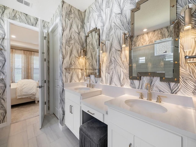 bathroom with a sink, visible vents, an enclosed shower, and wallpapered walls