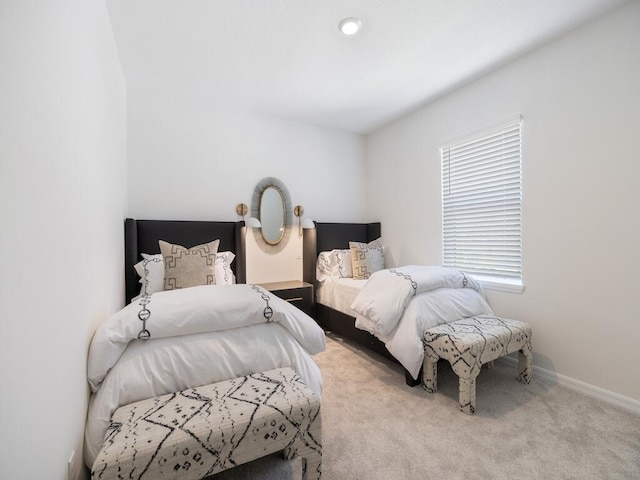 bedroom with baseboards and light carpet