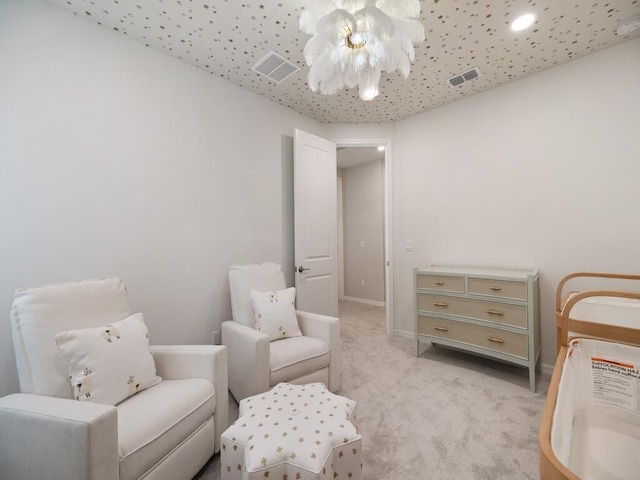 sitting room featuring an inviting chandelier, light colored carpet, visible vents, and baseboards