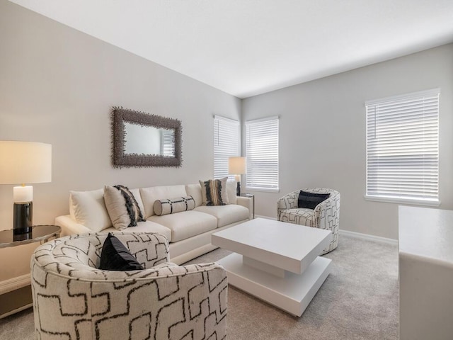 living area with baseboards and light colored carpet