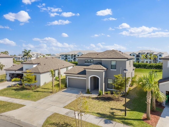 mediterranean / spanish-style house featuring stucco siding, a residential view, an attached garage, and a front yard