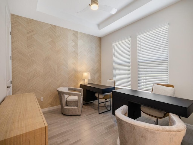 office with a raised ceiling, wood tiled floor, and ceiling fan