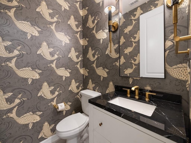 bathroom featuring visible vents, toilet, vanity, and wallpapered walls