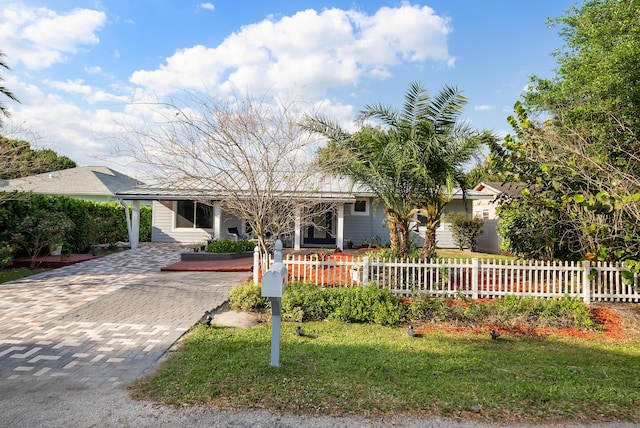 ranch-style home featuring a fenced front yard and decorative driveway