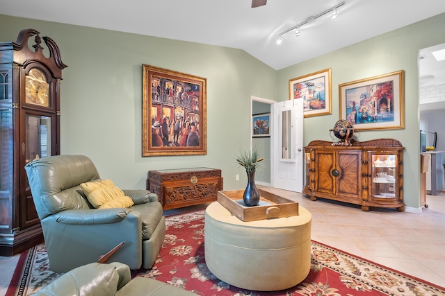 living area with track lighting, ceiling fan, baseboards, lofted ceiling, and light tile patterned floors