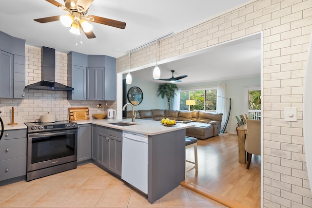 kitchen featuring stainless steel electric range, gray cabinets, white dishwasher, a sink, and wall chimney exhaust hood