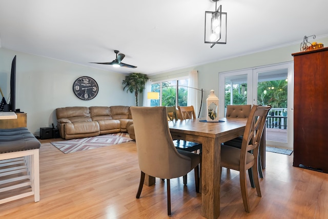 dining space featuring a ceiling fan, light wood-type flooring, french doors, and ornamental molding