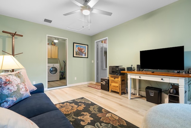 living area featuring wood finished floors, baseboards, visible vents, washer / dryer, and ceiling fan