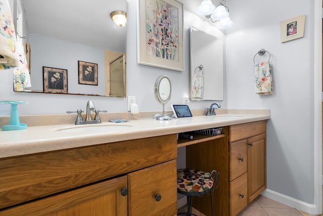 full bath with a sink, baseboards, double vanity, and tile patterned flooring