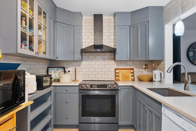 kitchen featuring gray cabinetry, dishwasher, stainless steel electric range oven, wall chimney exhaust hood, and a sink