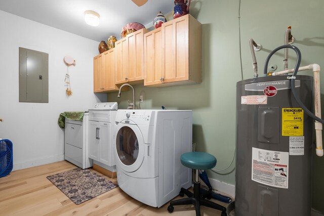 washroom with electric panel, washer and dryer, electric water heater, cabinet space, and light wood-style floors