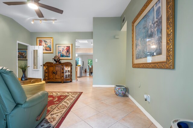 sitting room with light tile patterned floors, a ceiling fan, visible vents, and baseboards