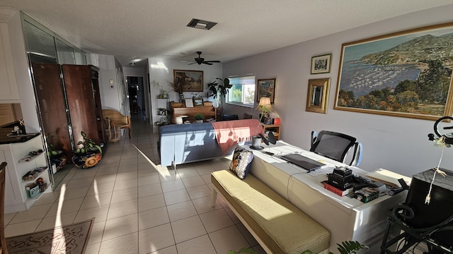 dining room with light tile patterned flooring, visible vents, a textured ceiling, and ceiling fan