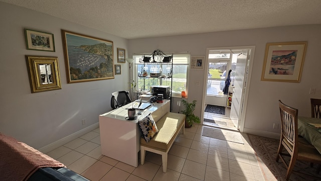 office space featuring light tile patterned flooring, baseboards, and a textured ceiling