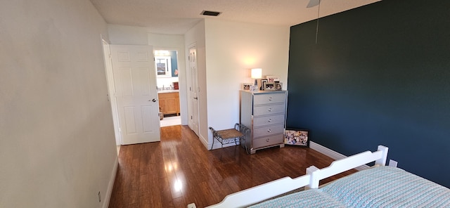 bedroom featuring visible vents, baseboards, wood finished floors, and a ceiling fan