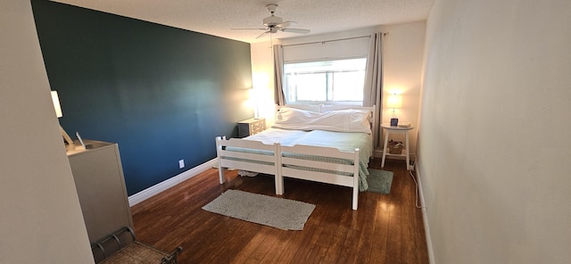 bedroom featuring baseboards, a textured ceiling, wood finished floors, and a ceiling fan