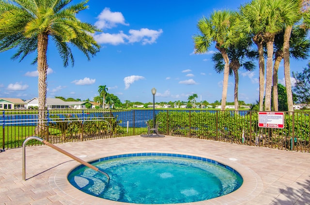 view of swimming pool featuring a hot tub and fence