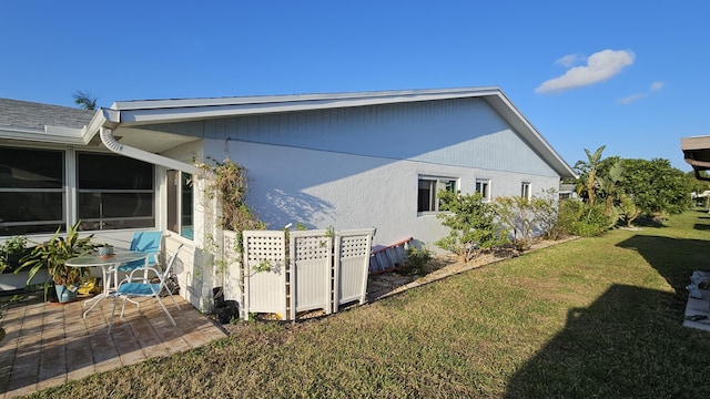 view of home's exterior with a patio area, stucco siding, and a yard