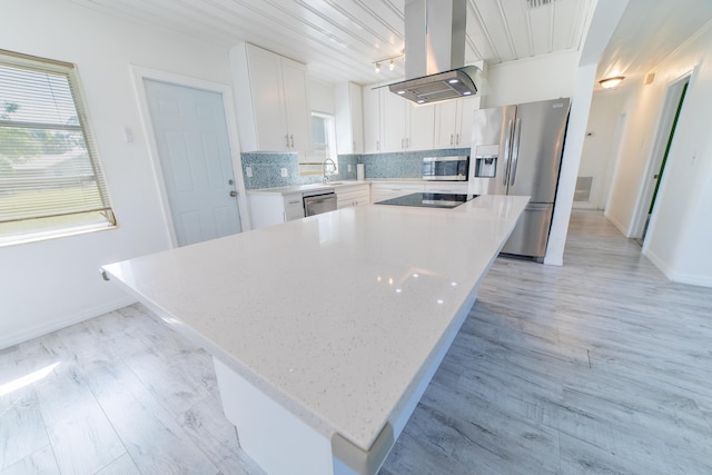 kitchen featuring tasteful backsplash, plenty of natural light, appliances with stainless steel finishes, and island exhaust hood