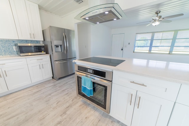 kitchen with decorative backsplash, white cabinetry, appliances with stainless steel finishes, and ventilation hood