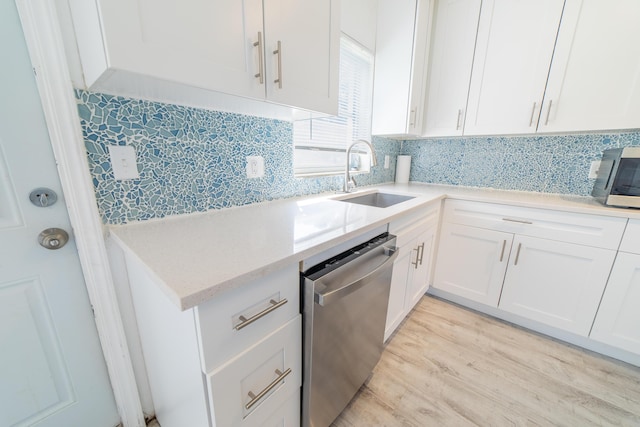 kitchen featuring a sink, decorative backsplash, white cabinets, and stainless steel appliances