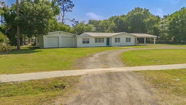 view of front of property with a garage, metal roof, a front lawn, and dirt driveway