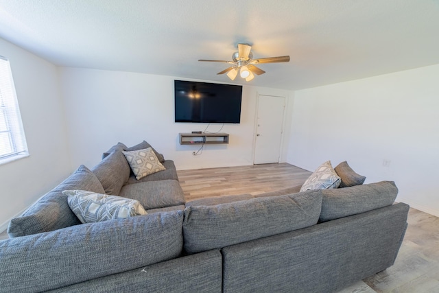 living area with a ceiling fan and wood finished floors