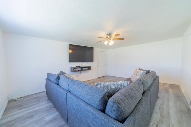 living room with wood finished floors, a ceiling fan, and baseboards