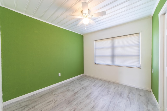 unfurnished room with a ceiling fan, wood finished floors, and baseboards