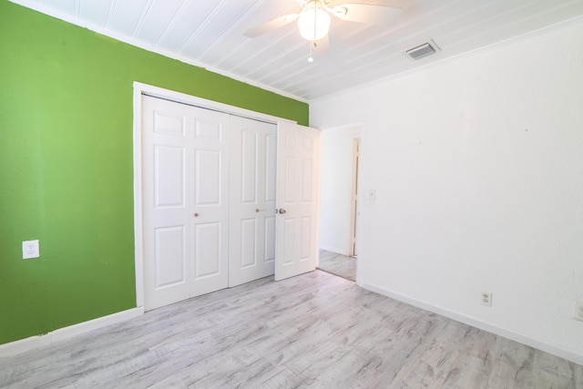 unfurnished bedroom with visible vents, baseboards, a closet, and wood finished floors