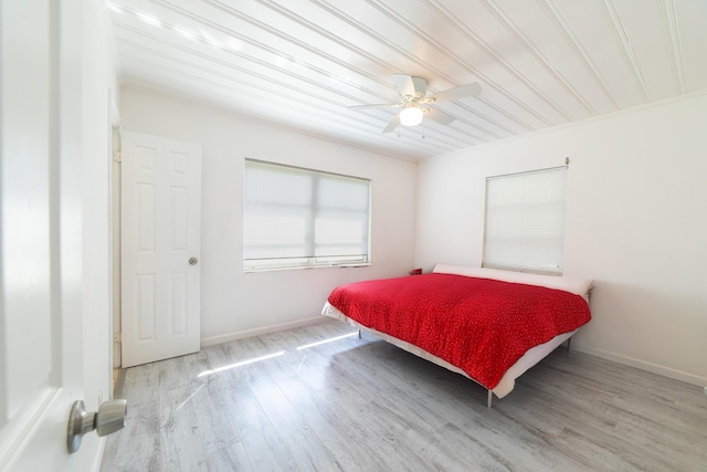 bedroom featuring a ceiling fan, baseboards, and wood finished floors