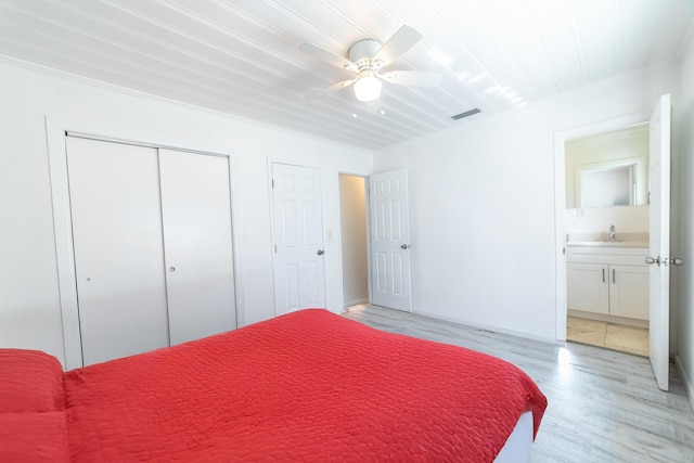 bedroom featuring light wood-type flooring, visible vents, a sink, a closet, and ceiling fan