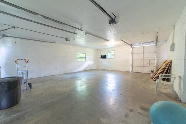 garage featuring concrete block wall and a garage door opener