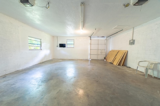 garage featuring a garage door opener and concrete block wall