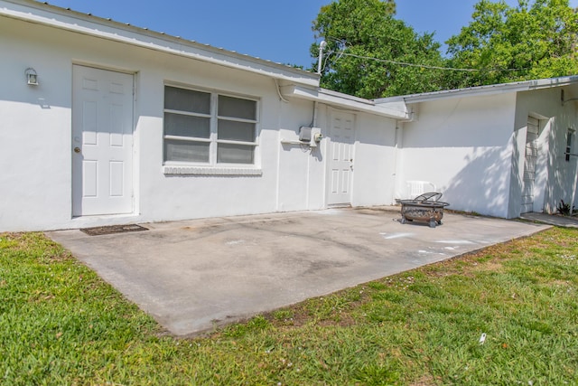 doorway to property with a yard, a patio area, and stucco siding