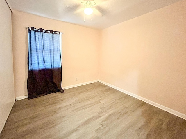 empty room with baseboards, ceiling fan, and wood finished floors